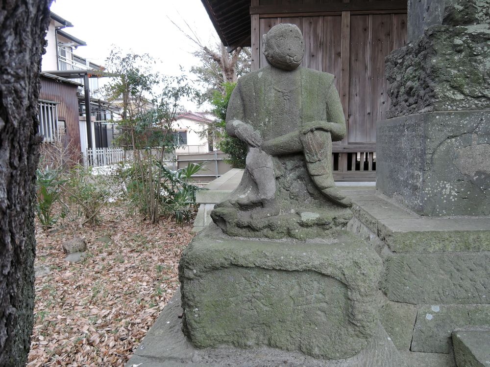 丸彫りの猿像｜足を組んで座っている